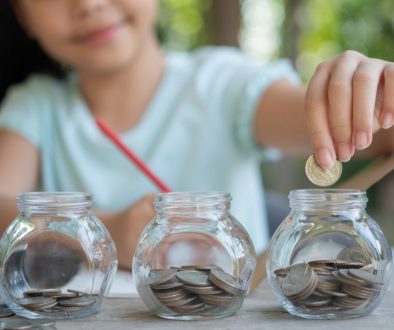 cute-asian-little-girl-playing-with-coins-making-stacks-money-kid-saving-money-into-piggy-bank-into-glass-jar-child-counting-his-saved-coins-children-learning-about-future-concept